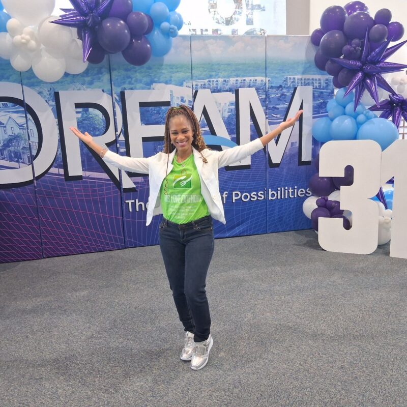 Sharise Dorsey posing in front of New Life's DREAM background
